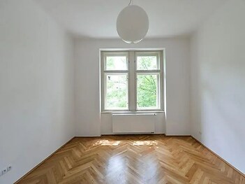 prázdná místnost s radiátor, parketová podlaha, a přirozené světlo