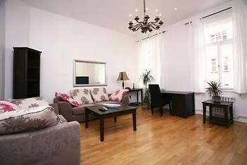 obývací pokoj s pozoruhodný lustr, dřevěná podlaha, a přirozené světlo